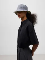 Sombrero impermeable reversible con logo bordado, diseñado para adaptarse a diferentes estilos.