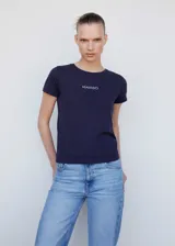 Camiseta blanca de algodón con cuello redondo y logo de la marca Mango estampado en color dorado en el pecho.