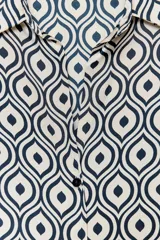 Camisa de manga larga con cuello solapa y estampado geométrico en tonos azul marino y blanco.