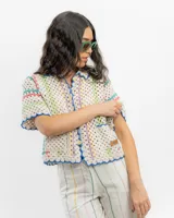 Saco tejido a crochet a mano con detalles en azul y amarillo.