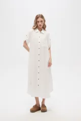 Vestido camisero midi negro de corte holgado, con cuello camisero, mangas cortas con trabillas, cierre frontal con botones, bolsillo en el pecho y bolsillos laterales.