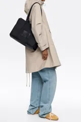 Bolso shopper negro de nailon con estructura blanda, doble asa de tejido, logo grabado BIMBA Y LOLA, acabados metálicos, bolsillo interior con cierre de presión, cierre de cremallera e interior con placa metálica logotipada.