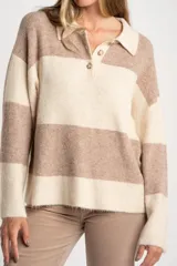 Sweater de punto con diseño de rayas horizontales en tonos beige y marrón claro. Cuenta con cuello polo, cierre frontal de tres botones, mangas largas y un calce oversize.