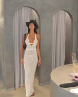 Vestido largo de tejido de punto color crema, con escote halter y aberturas laterales.