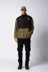 Campera negra con la parte superior de tela tipo rompevientos con dos bolsillos con solapa y la parte inferior de micro polar. Tiene cierre frontal y cuello alto.