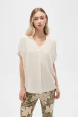 Blusa color beige de lino, holgada y con cuello en V.