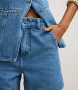 Short de jean azul claro, modelo mom, con cintura alta, cintura sastre y botón forrado.