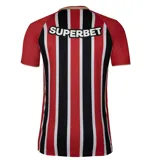 Remera de fútbol New Balance del São Paulo FC, modelo Home 2025. Diseño a rayas verticales rojas, blancas y negras con mangas rojas y detalles dorados en cuello y puños. Incluye logo de New Balance, escudo del club y sponsor Superbet en el frente.