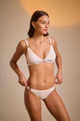 Top de bikini rosado con textura arrugada y detalles de aros dorados en los tirantes y en la bombacha.