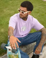 Remera color beige de algodón premium, manga corta y cuello redondo. Presenta un estampado circular en el centro del pecho con un diseño abstracto en tonos grises.