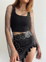 Minifalda negra con volados en el ruedo y cintura alta con cinturón de cuero con apliques metálicos.