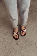 Sandalias tipo ojotas con base acolchada y estampado animal print de vaca en marrón y blanco.