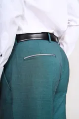 Traje de vestir gris claro, compuesto por saco de dos botones con solapa de muesca, bolsillo de ojal y dos bolsillos de parche. Incluye pantalón de vestir a juego.