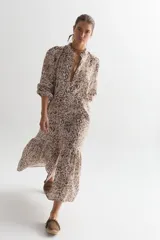 Vestido midi con estampado floral en tonos marrón y blanco, cuello mao, mangas 3/4 abullonadas y corte evasé.