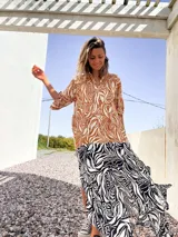 Vestido camisero largo con estampado de hojas en tonos marrones y blancos en la parte superior, y estampado de cebra en blanco y negro en la parte inferior.