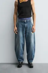 Pantalón de jean azul de corte amplio, con roturas y lavado gastado.