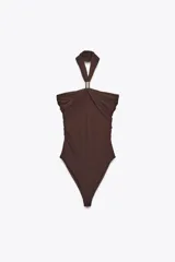 Body marrón de poliamida con cuello halter y pieza metálica dorada. Detalle de frunces y cierre inferior con botones a presión.