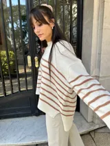 Sweater tejido color marrón con rayas horizontales blancas, cuello redondo y corte holgado.