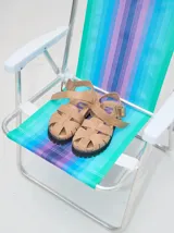 Sandalias de cuero color beige con tiras entrecruzadas, hebilla lateral y suela de goma negra.