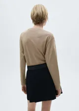 Remera color beige de manga larga con cuello redondo.