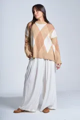 Sweater de punto con diseño de rombos en tonos beige y blanco, cuello redondo y corte holgado.