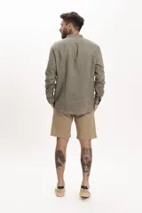 Camisa de lino color verde oliva, corte slim, cuello mao y mangas largas con puños abotonados.