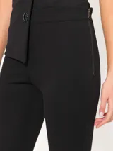 Pantalón negro acampanado confeccionado en j-tecno e fit flare, con cintura elástica, cierre lateral, recortes en el delantero y ruedo con godets que aportan amplitud.