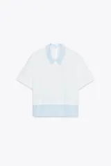 Camiseta blanca de cuello redondo con solapa combinada a contraste de rayas celestes. Manga corta. Bajo con tejido combinado de rayas celestes. Cierre en espalda con abertura y botón.