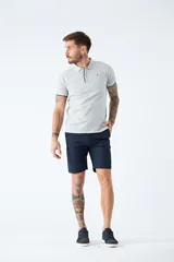 Bermuda de gabardina azul marino con logo bordado, bolsillos laterales y traseros, cierre con cremallera y botón, y presillas para cinturón.