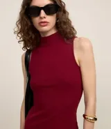Vestido midi de punto acanalado color borgoña, con cuello alto y sin mangas. Corte recto y textura acanalada.