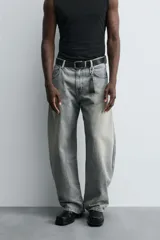 Pantalón de jean celeste con efecto lavado, corte holgado desde la cadera que se estrecha ligeramente en el bajo, tiro medio, cinco bolsillos y cierre frontal con cremallera y botón.