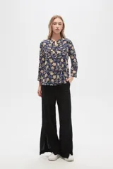 Camisa de viscosa con estampado floral en tonos azul, beige y blanco. Tiene cuello mao, mangas largas y bolsillos en el pecho.
