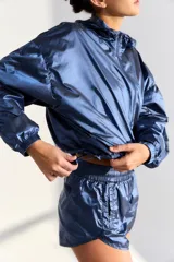 Campera deportiva azul de poliamida con cierre frontal y bolsillos laterales.