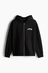 Campera negra con capucha, cierre frontal y bolsillos laterales. Estampado blanco con texto en el pecho.
