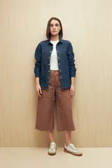 Pantalón capri color beige de algodón, con corte acampanado, bolsillos laterales tipo cargo y cintura con cordón ajustable.