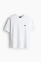 Remera blanca de corte holgado con cuello redondo y estampado pequeño con la frase "New York" en el pecho.
