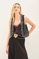 Chaleco negro con lentejuelas y apliques plateados, escote en V y cierre frontal con gancho oculto.