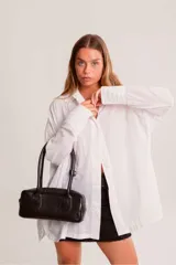 Cartera tipo baguette de cuero color amarillo pálido, con asas cortas y estructura rectangular.