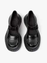 Zapato tipo Mary Jane color negro, con correa con hebilla y plataforma con suela track.