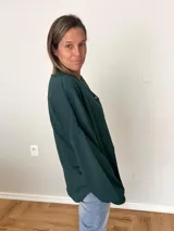 Remera verde con botones en el escote, de manga larga y corte recto.