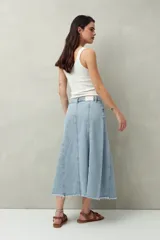 Falda midi de denim negro con tiro bajo, corte evasé, costuras verticales y ruedo desflecado.