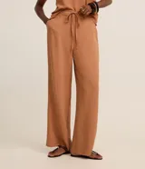 Pantalón femenino modelo wide leg, confeccionado en crepé airflow, con cintura alta y cordón para lazo en la cintura. Sin estampado, posee bolsillos y puntas metalizadas.