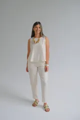 Pantalón de vestir color crudo, de corte recto, con bolsillos laterales y traseros. Se ajusta a la cintura con cierre y botón.