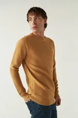 Sweater mostaza de punto con cuello redondo, mangas largas y logo bordado en el pecho. Corte slim fit.