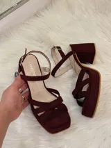 Sandalias de plataforma color vino con tiras cruzadas y tobillera con hebilla.