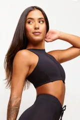 Top deportivo negro con cuello halter y espalda descubierta. Confeccionado en poliamida y elastano con protección UV50+.