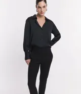 Pantalón cigarrete negro de algodón satinado con cintura elástica en la espalda, bolsillos traseros y cierre delantero con cremallera.