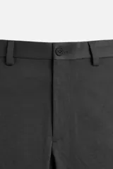 Pantalón chino negro slim fit confeccionado en tejido técnico de secado rápido. Cuenta con bolsillos frontales y traseros de vivo. Cierre frontal con cremallera y botón.