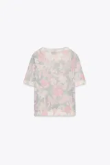 Top de punto con estampado floral en tonos rosa, gris y blanco. Tiene cuello redondo, mangas cortas y terminaciones acanaladas.