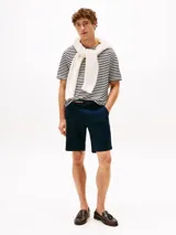 Bermuda azul marino de sarga de algodón elástico, con cinturón a rayas rojas y blancas, cierre de cremallera, bolsillos delanteros de parche y bolsillos traseros de ojal con botón.